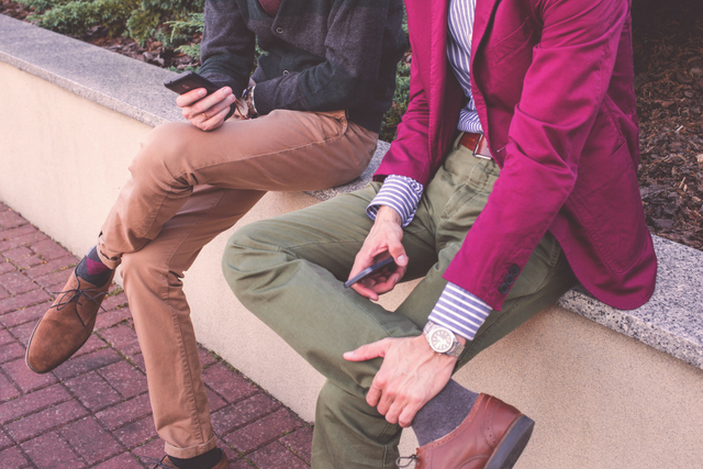 completi spezzati indossati da millennials con smartphone alla mano