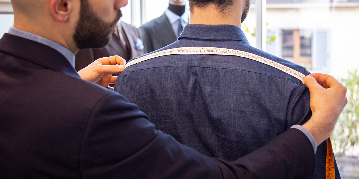 A style advisor taking customers Shoulder width measurements at Lanieri's Atelier