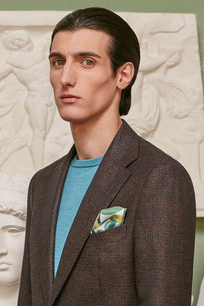 Giacca marrone indossata su maglione girocollo azzurro